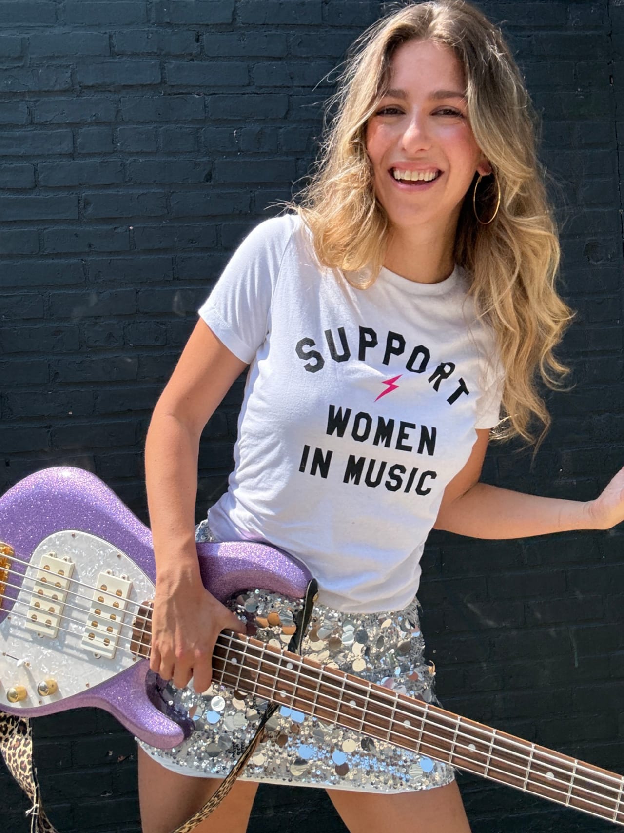 A bass player wearing a Support Women In Music shirt